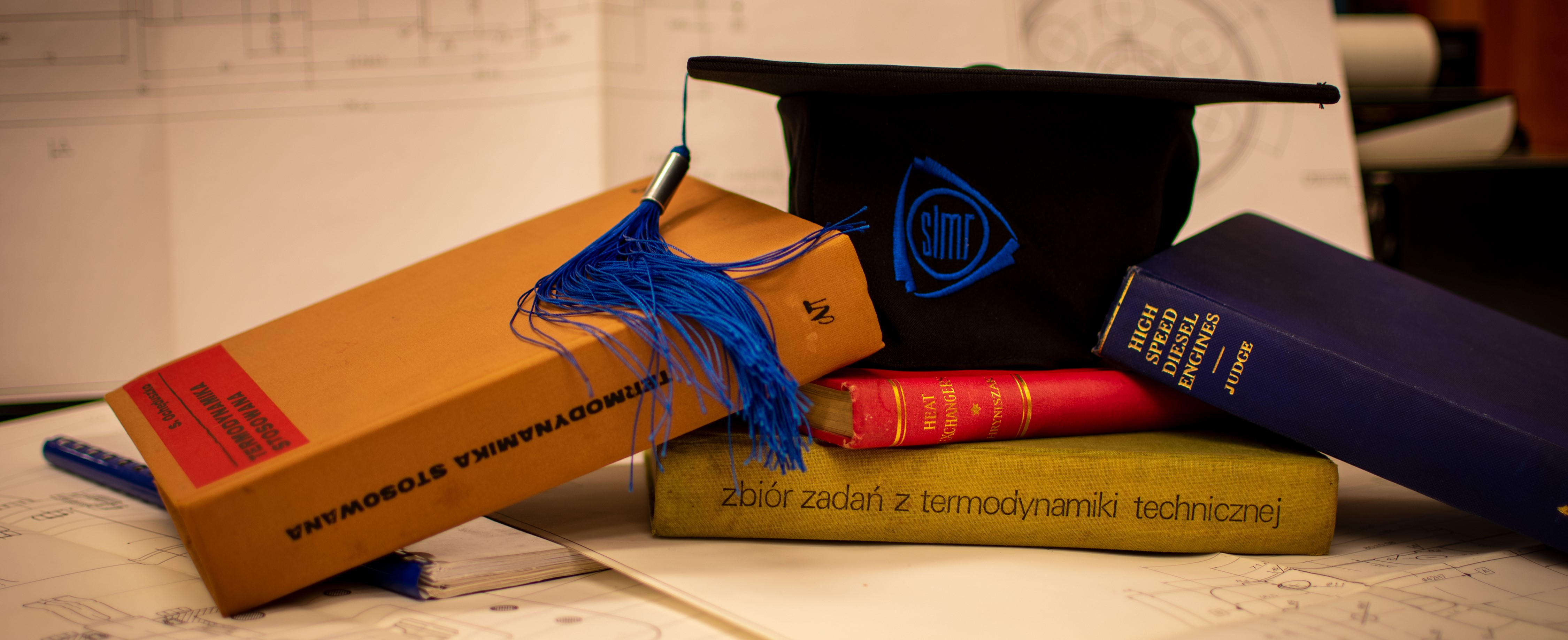 Czapka absolwenta Wydziału SiMR leżąca na podręcznikach.