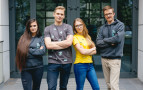 Fotografia czterech młodych osób w strojach z logo PW