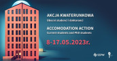 On the left, a tall red building, on the right, the inscriptions "Akcja Kwaterunkowa" and "Accomodation action"
