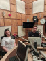 Dwoje studentów siedzących w studiu radiowym.