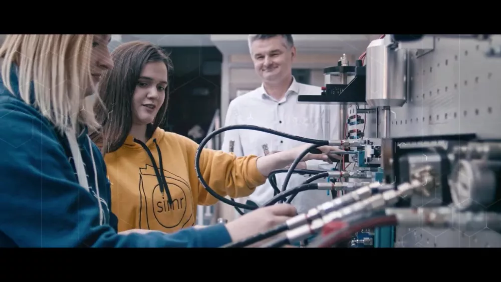 Trzy osoby przy skomplikowanym urządzeniu